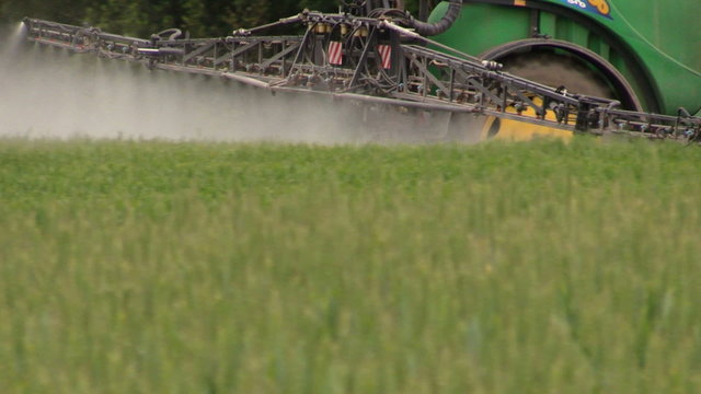 Follow tractor spray field plants with chemical pesticide