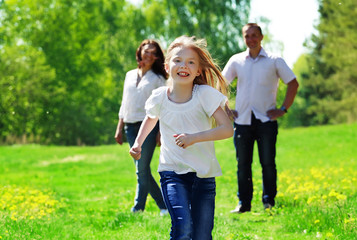 Fototapeta premium Happy young girl running from her parents