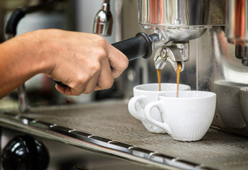 prepares espresso in his coffee shop