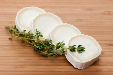 Ziegenkäse mit Thymian auf Holzbrett.