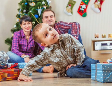 Young family under the christmas tree at home