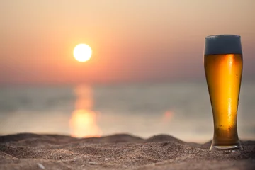 Rolgordijnen Glas bier op een zonsondergang © merydolla