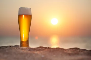 Foto op Canvas Glas bier op een zonsondergang © merydolla