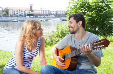 Junges Paar entspannt mit Musik auf der Wiese