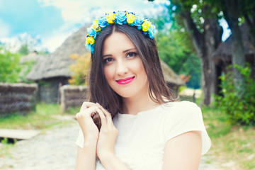 beautiful young woman wearing blue and yellow wreath and posing