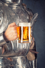 knight wearing armor and holding mug of beer