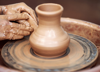 Hands working on pottery wheel