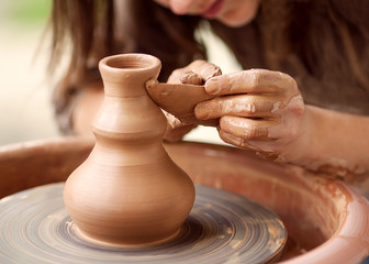 Hands working on pottery wheel