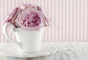 Cup filled with a bouquet of pink roses