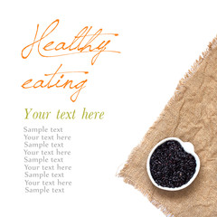 Black organic rice in bowl isolated on white