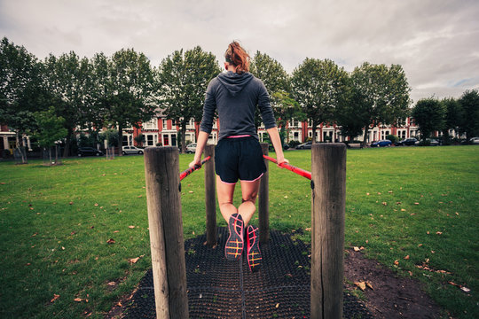 Young woman doing dips in the park