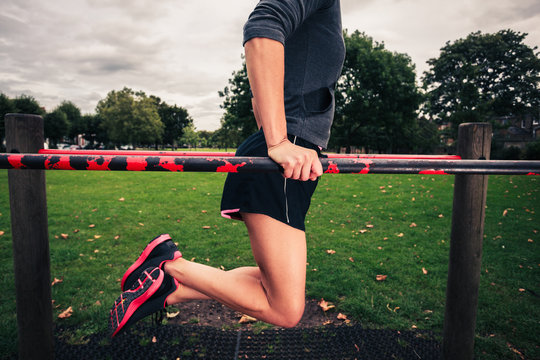 Young woman doing dips in the park