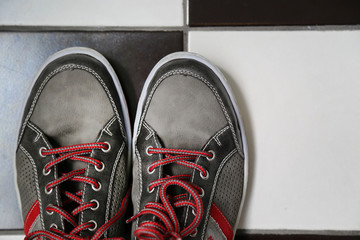 Cropped image of gray shoes with vivid red laces