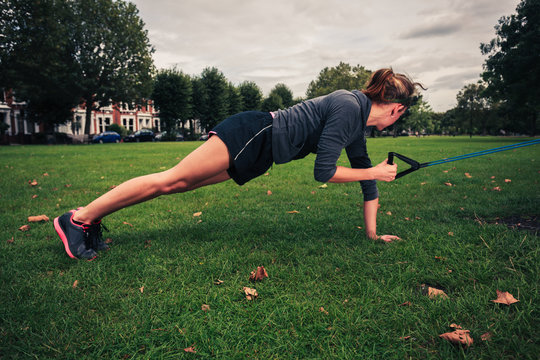 Woman working out with resistance band in the park