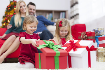 Obraz na płótnie Canvas Sweet little girls opening Christmas presents