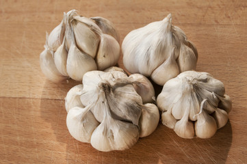 Four garlic cloves on wooden board background