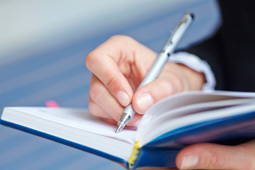 Female hand writing in notebook