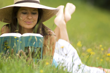 Junge Frau liest ein Buch , in der Wiese liegen