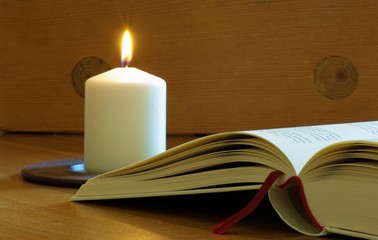 Aufgeschlagenes Buch mit Kerze