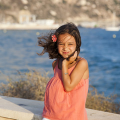 Niña en paseo marítimo con viento en el pelo
