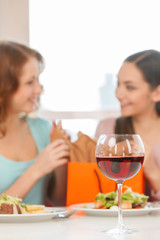 blurred image of two teenage girls talking in cafe.