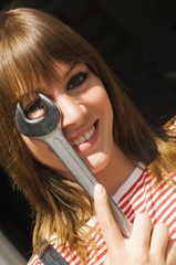 Fototapeta premium Junge Frau, die ein Gabelschlüssel hält, Portrait