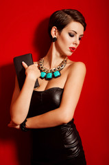 Beautiful girl with a clutch bag in her hands