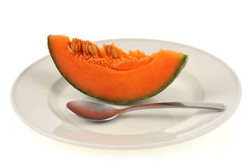 Tranche de melon avec ses pépins dans une assiette