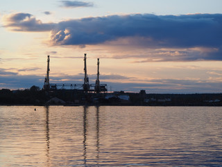 an industrial city on the shore of lake at sunset