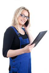 Frau im Blaumann mit digitalem Tablet und Mobiltelefon