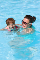 Family in swimming pool playing