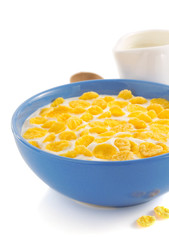 corn flakes and milk in bowl on white