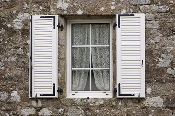 Granitfassade mit modernem Kunststofffenster und PVC-Klappladen