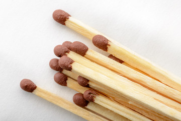 Close-up of matches on white paper background