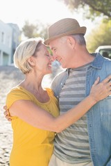 Happy mature couple smiling at each other in the city