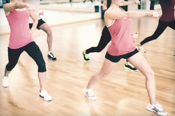 group of smiling people exercising in the gym