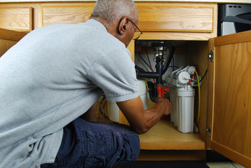 Man making under sink repairs