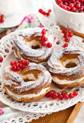 Cream puff rings decorated with fresh red currant