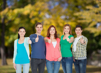 group of smiling students showing thumbs up