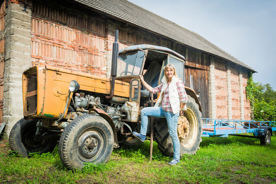 Frau mit alten Trecker auf dem Land