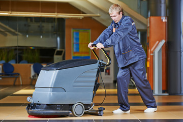 Fototapeta na wymiar worker cleaning floor with machine