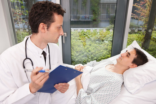 Arzt kommt zur Visite ans Krankenbett