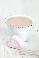 hot chocolate and heart-shaped marshmallow on wooden surface