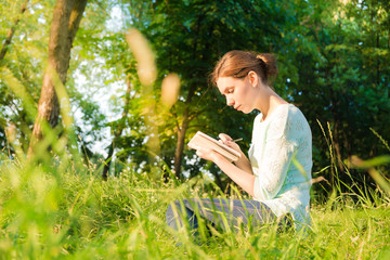 girl sitting in park and writing