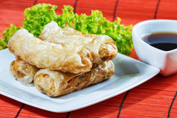 fried spring rolls on red bamboo mat