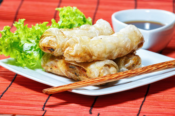 fried spring rolls on red bamboo mat
