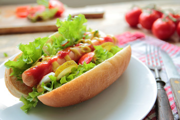 Homemade hotdog with fresh vegetable on a white plate