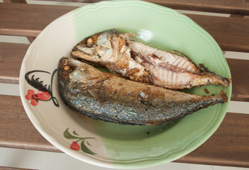 Fried Mackerel in dish on wooden table.