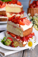 Delicious biscuit cake with strawberries on table close-up