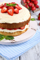 Delicious biscuit cake with strawberries on table close-up